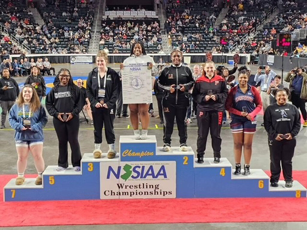 Shellitha Collins (center) stands atop the podium
