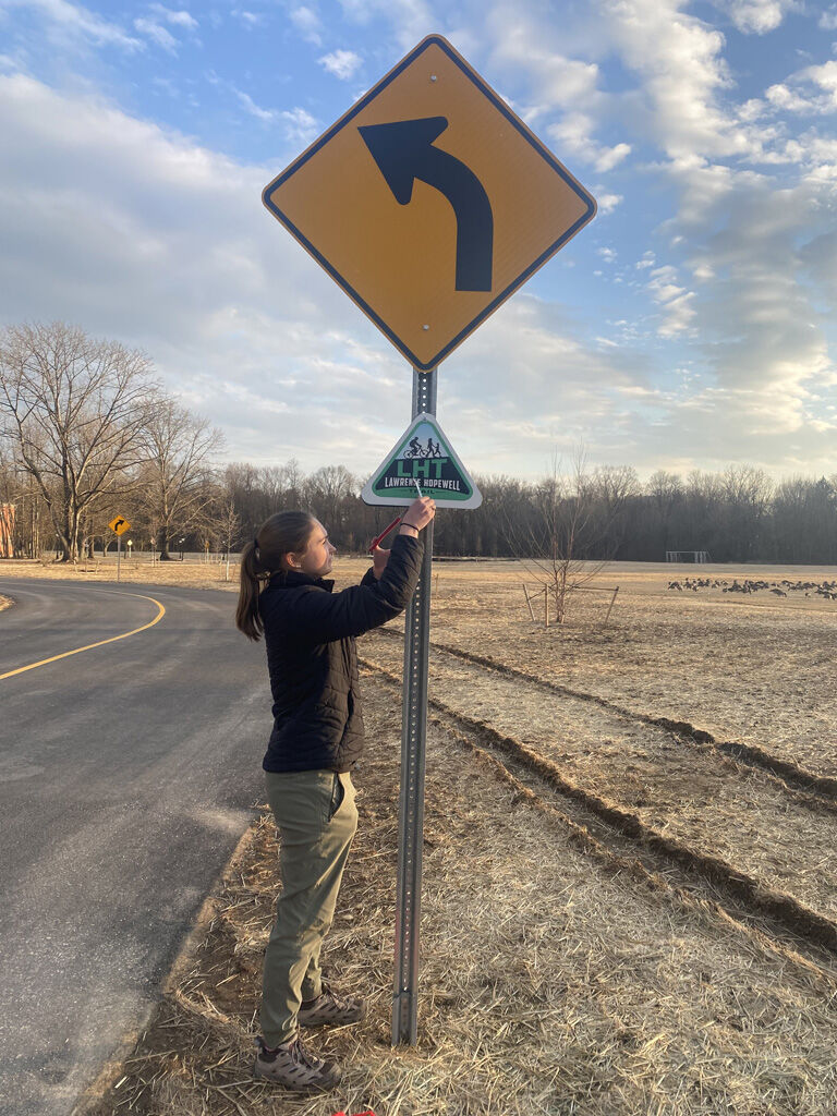 claire wille installs LHT sign at Lawrenceville School